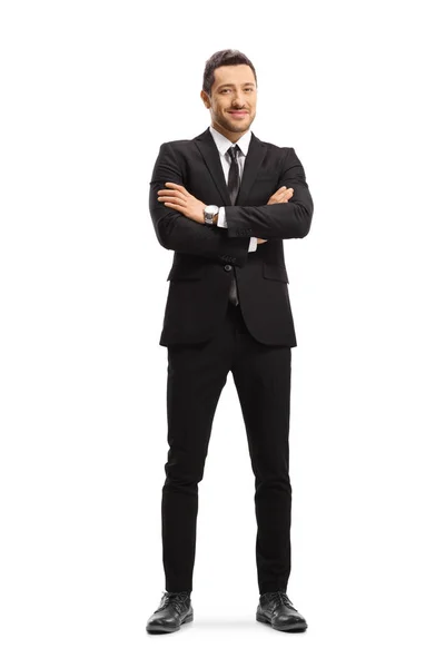 Empresario vestido con un traje negro y posando con los brazos cruzados —  Fotos de Stock