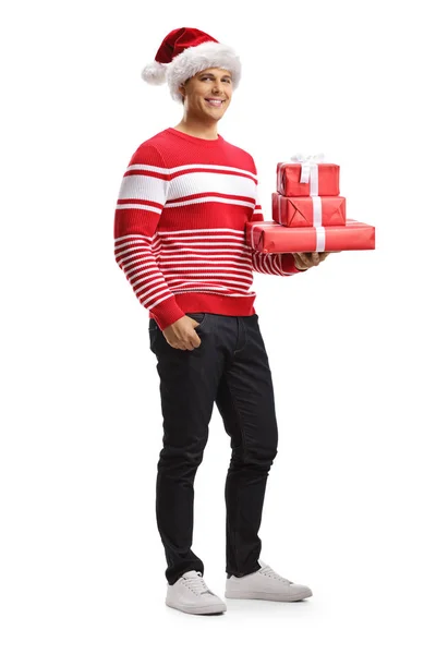 Junger Mann mit Weihnachtsmann-Hut und Weihnachtsgeschenken — Stockfoto