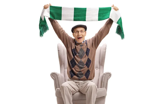 Homme âgé excité dans un fauteuil acclamant avec une écharpe — Photo