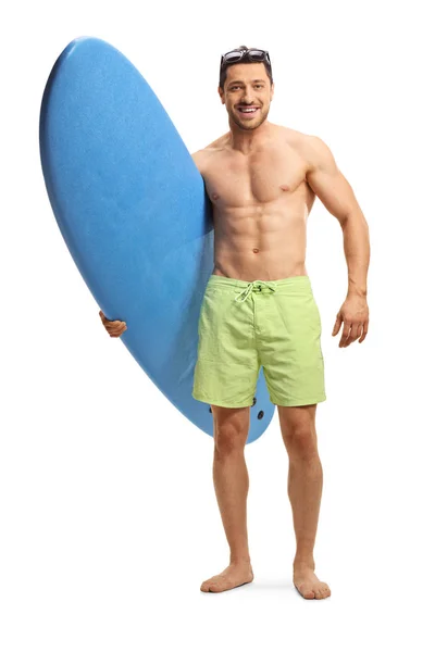 Genç yakışıklı adam bir sörf tahtası tutan ve gülümseyen — Stok fotoğraf