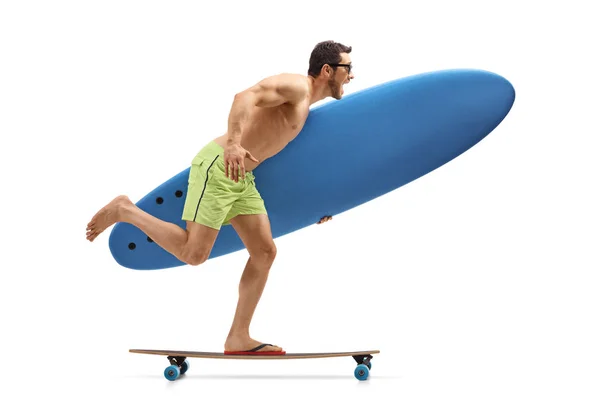 Ung man som innehar en surfbräda och rida en longboard — Stockfoto