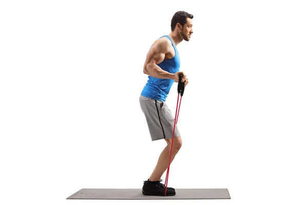 Bir direnç bandı ile bir egzersiz mat üzerinde Adam — Stok fotoğraf