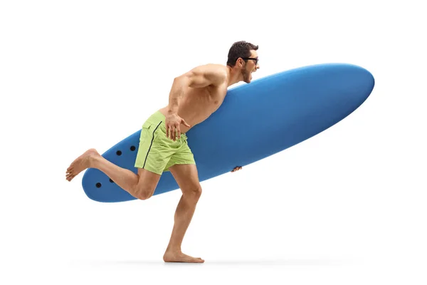 Joven hombre excitado sosteniendo una tabla de surf y corriendo — Foto de Stock