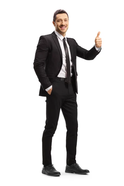 Молодой бизнесмен в черном костюме показывает большие пальцы вверх — стоковое фото