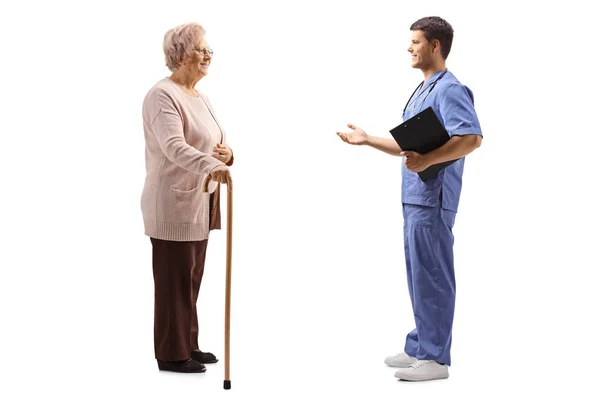 Médico do sexo masculino explicando algo para uma paciente idosa — Fotografia de Stock