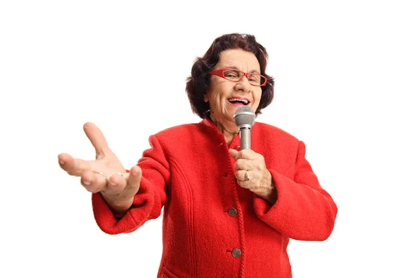 Allegro signora anziana che canta su un microfono e gode — Foto Stock