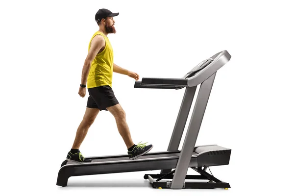 Bearded guy in sportswear walking on a treadmill with an incline — Stock Photo, Image