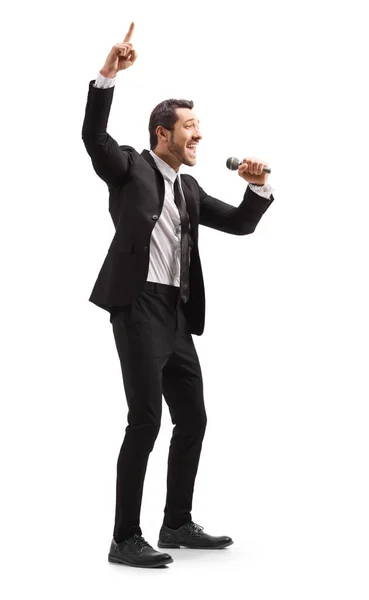 Man in a suit with a microphone pointing up — Stock Photo, Image