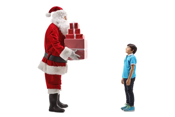 Święty Mikołaj dając stos prezentów dla chłopca — Zdjęcie stockowe