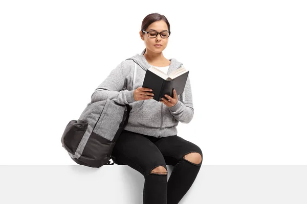 Female student sitting on a panel reading a book — Stock Photo, Image