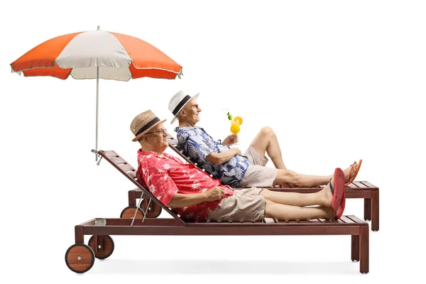 Due uomini anziani in vacanza a godersi un cocktail su un lettino sotto — Foto Stock