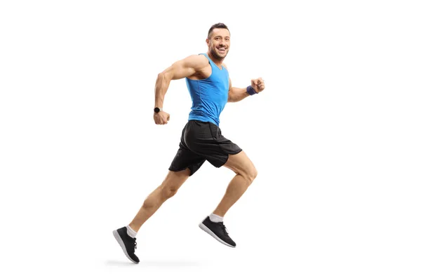 Mladý muž ve sportovním oblečení běží a dívá se na kameru — Stock fotografie