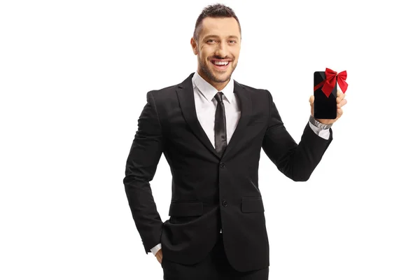 Homme joyeux dans un costume tenant un téléphone portable présent — Photo