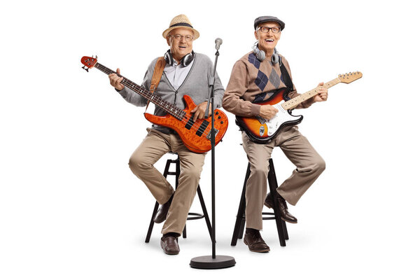 Two senior men sitting and playing electric guitars