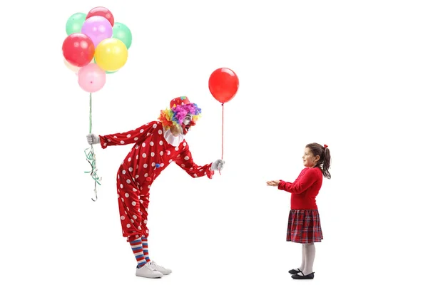 Payaso dando un globo a una niña y sosteniendo un montón de b —  Fotos de Stock