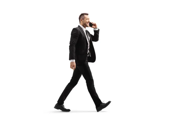 Affärsman går och pratar på en mobiltelefon — Stockfoto