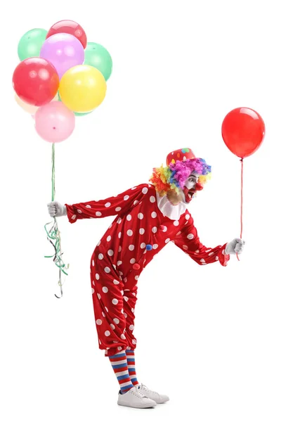 Clown gibt einen Ballon aus einem Bündel Luftballons — Stockfoto