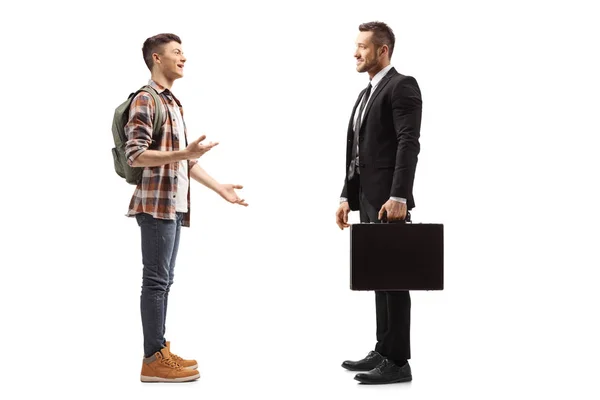 Підлітковий студент чоловічої статі з рюкзаком розмовляє з чоловіком у костюмі — стокове фото