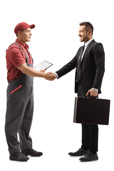 Arbetstagare i en Uniform skakar hand med en ung man i en kostym wit — Stockfoto
