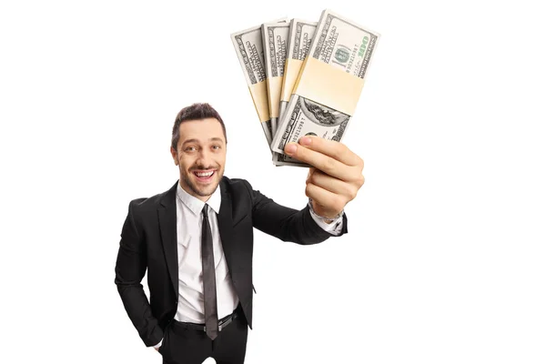 Affärsman som innehar högar av dollar framför kameran — Stockfoto