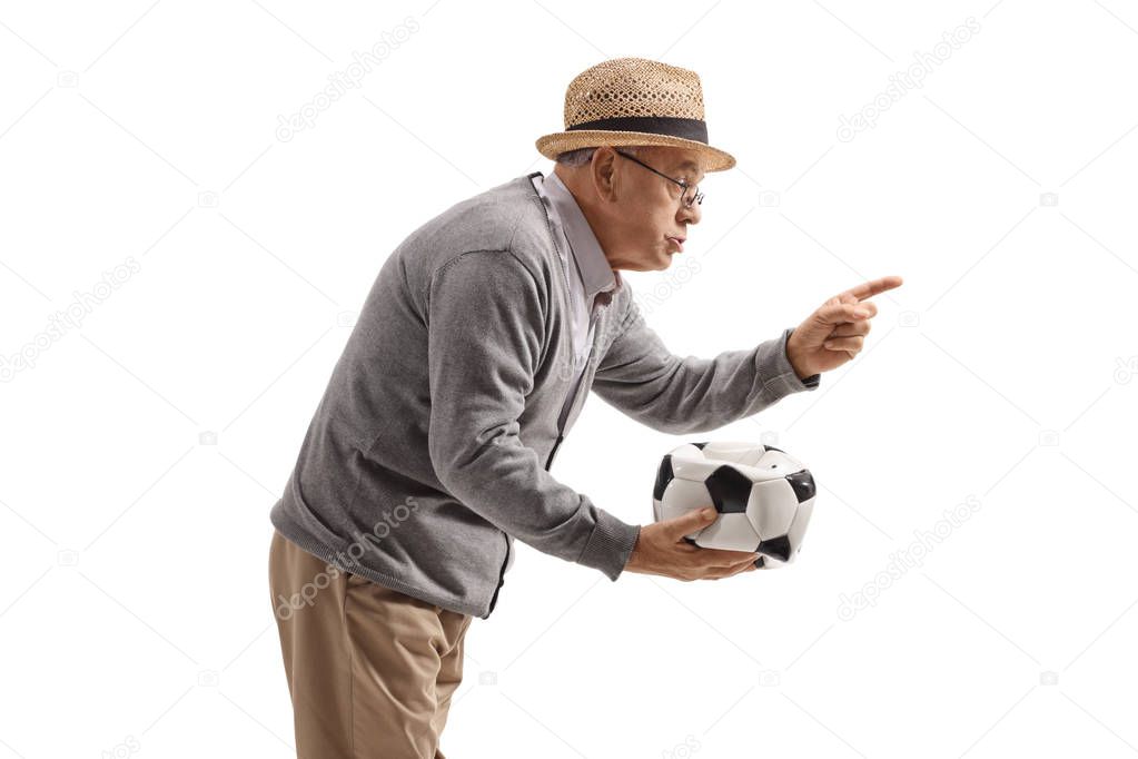 Grumpy old man holding a deflated football and scolding someone