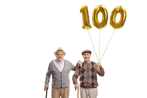 Two senior men with a golden number hundred balloon — Stock Photo, Image