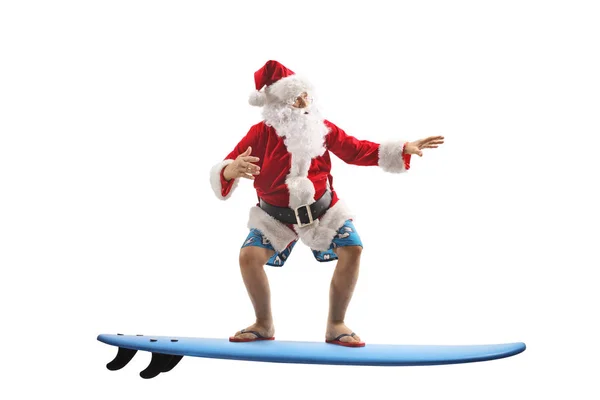 Santa Claus in swimming shorts on a surfboard — Stock Photo, Image