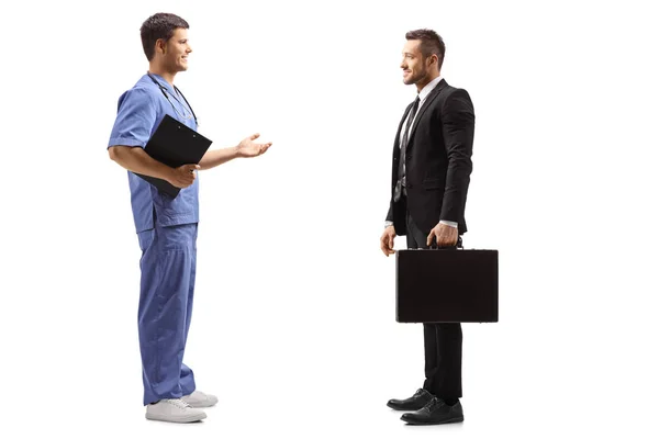 Мужчина-врач в синей форме разговаривает с бизнесменом с BR — стоковое фото