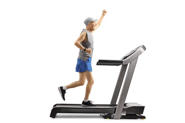 Senior man running on a treadmill and gesturing with hand — Stock Photo, Image