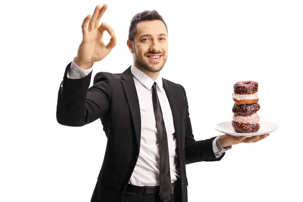 Geschäftsmann mit einem Teller Donuts, der ein Zeichen für perfekten Witz setzt — Stockfoto