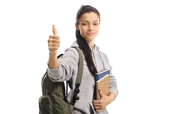 Söt kvinnlig student håller böcker och visar en tumme upp tecken — Stockfoto