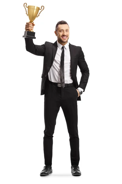 Lykkelig ung mand i jakkesæt holder en gylden trofæ kop - Stock-foto