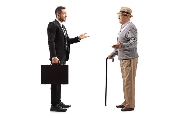 Businessman with a suitcase having a conversation with an elderl — Stock Photo, Image