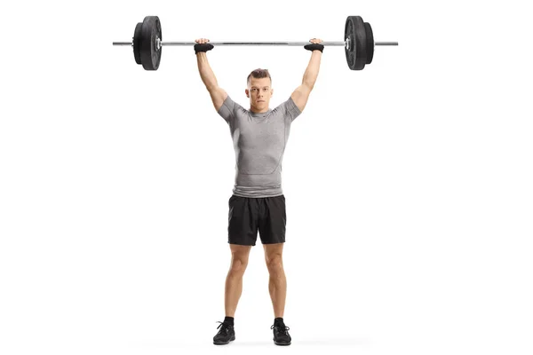 Junger muskulöser Kerl beim Heben von Gewichten — Stockfoto