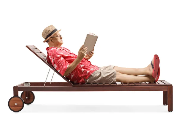 Signore maturo godendo su una sedia a sdraio durante la lettura di un libro — Foto Stock