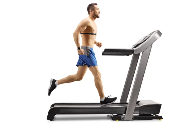 男子在跑步机上用胸部监视器跑步 — 图库照片