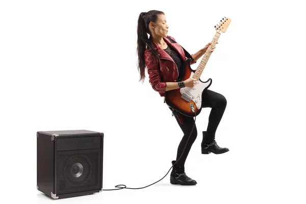 Guitarrista femenina tocando una guitarra enchufada a un amplificador — Foto de Stock