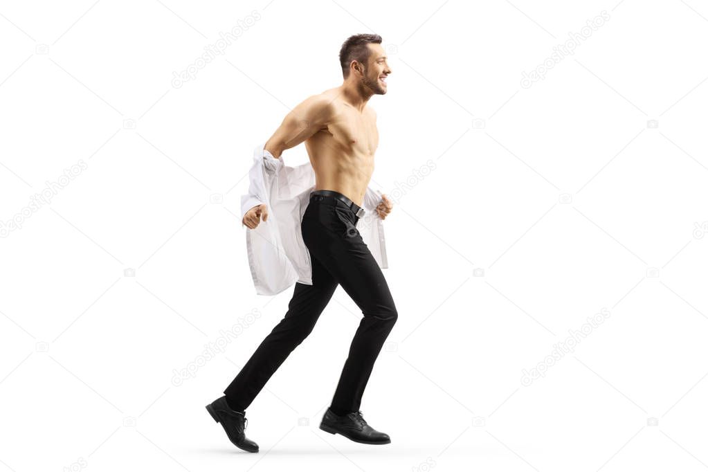 Young handsome man running and taking off his shirt 