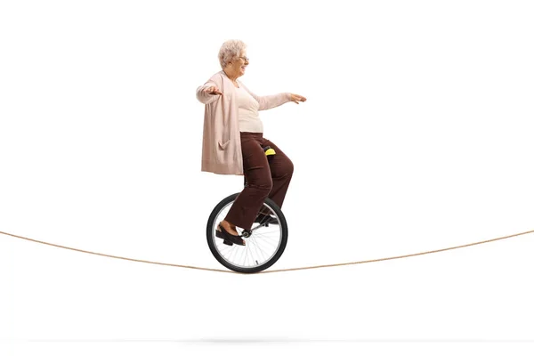 Старша жінка катається на мотузці на моноциклі — стокове фото