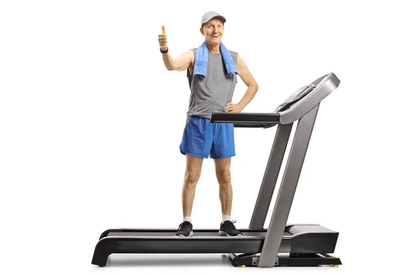 Hombre mayor parado en una cinta de correr y mostrando los pulgares hacia arriba —  Fotos de Stock
