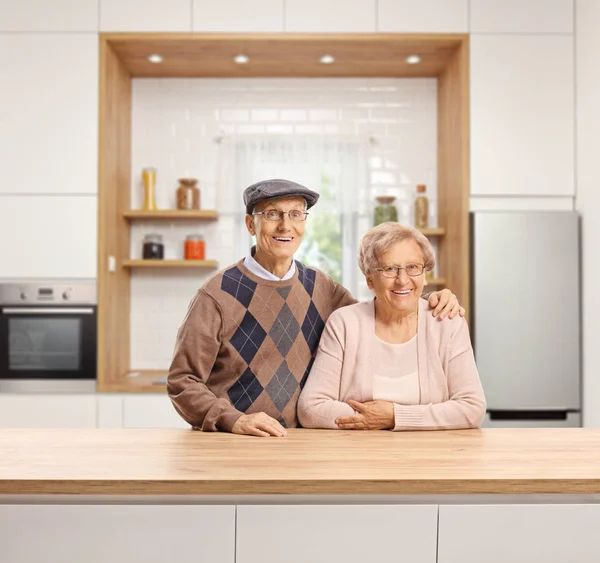 Elderly man and woman standing in a kitchen — Stock Photo, Image