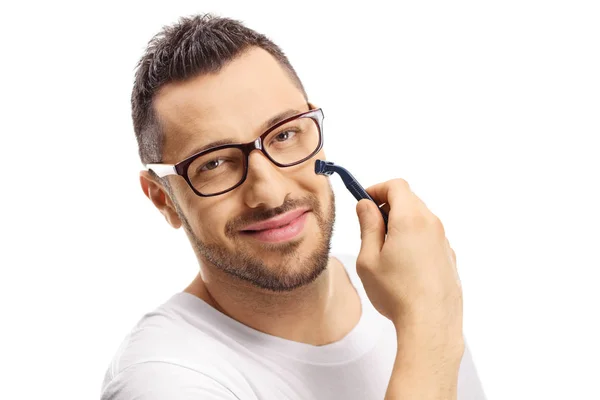 Bello giovane uomo con gli occhiali con un rasoio sul viso — Foto Stock