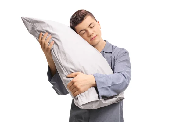 Maschio adolescente abbracciare un cuscino con gli occhi chiusi — Foto Stock