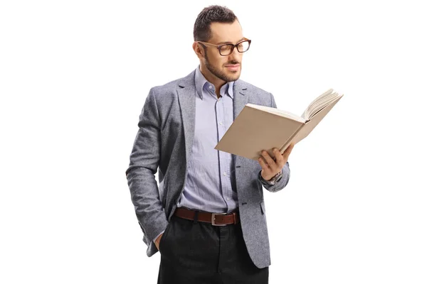 Junger Mann mit Brille steht und liest ein Buch — Stockfoto