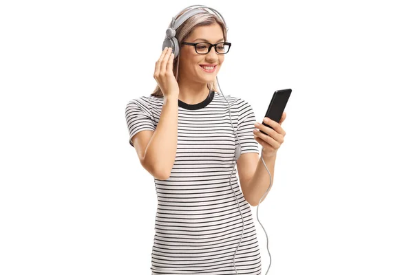 Giovane donna sorridente che ascolta musica su cuffie da un mobi — Foto Stock