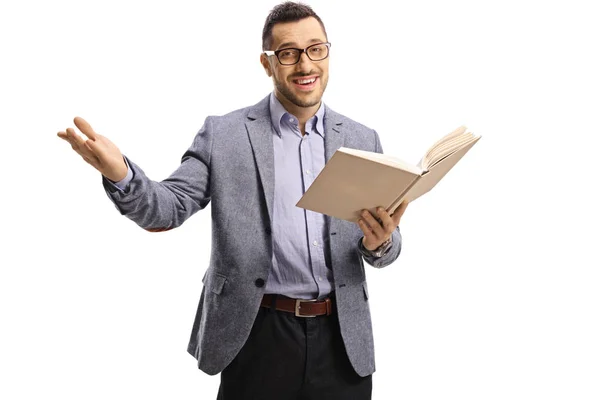 Junger Mann steht, hält ein aufgeschlagenes Buch in der Hand und gestikuliert mit h — Stockfoto