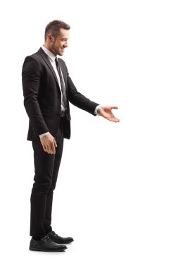 Takım elbiseli genç adam el ele gesturing ve bir şey alarak 