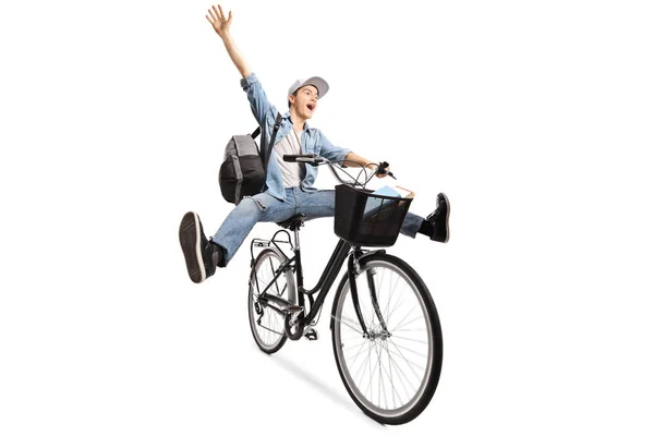 Energetic young male with a backpack riding a bicycle and gestur — Stock Photo, Image