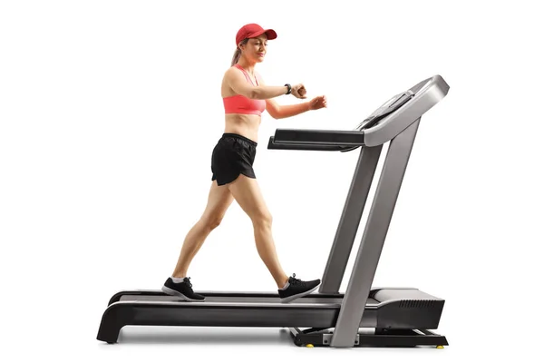 Young woman on a treadmill walking and checking her smart sports — Stock Photo, Image