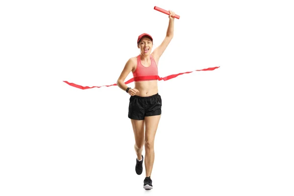 Young woman carrying a red baton and finishing a relay race — Stock Photo, Image